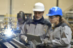 Apprentice working in steelworks plant, with instructor