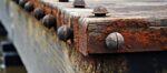 Close view of aged pier base with corroded bolts blank area available